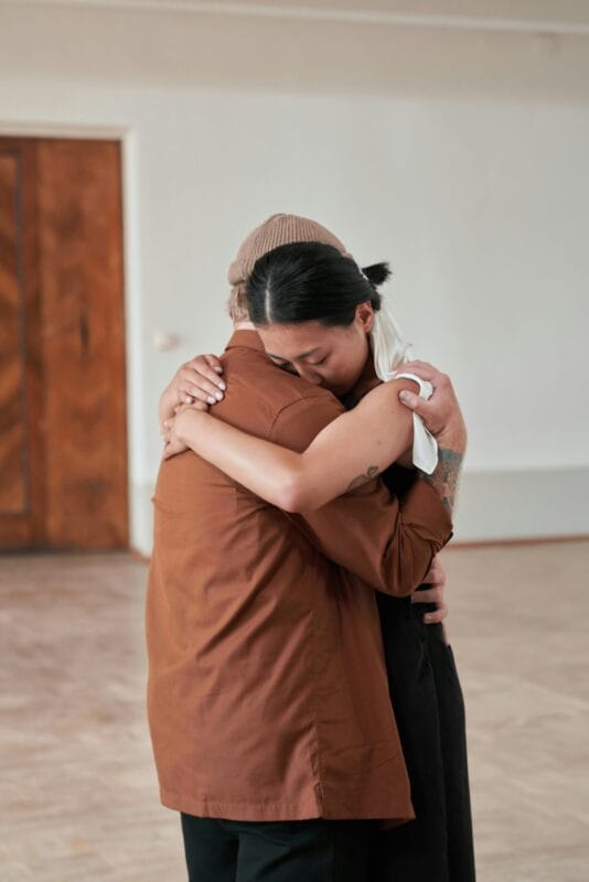 Pareja abrazándose después de resolver un conflicto, mostrando una comunicación efectiva y comprensión mutua.